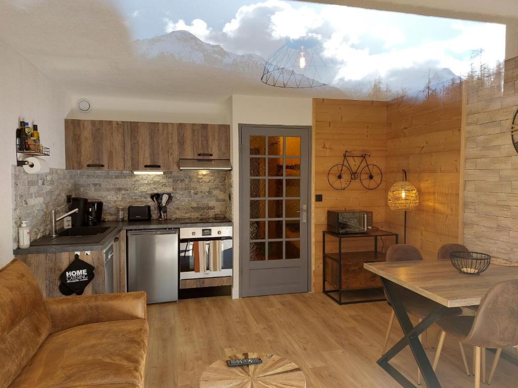 a living room with a kitchen and a dining room at Studio Le Flocon entièrement rénové in Les Orres