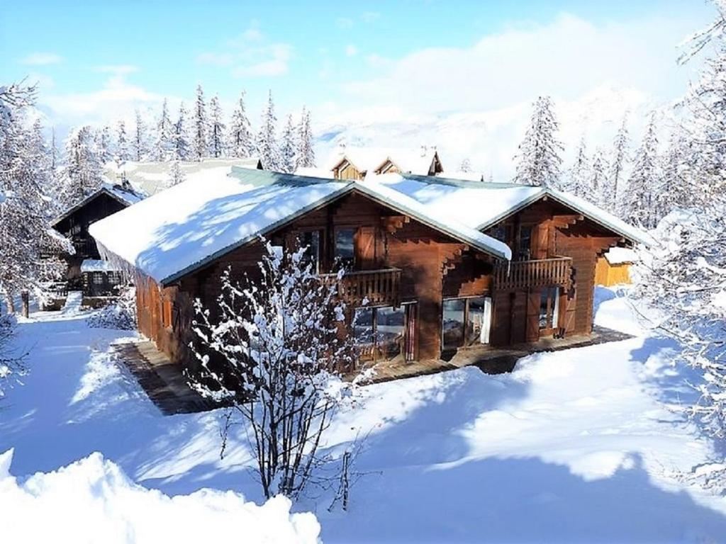 uma cabana de madeira está coberta de neve em CASA Les Heureux Magnifique CHALET 6 chambres à RISOUL em Risoul