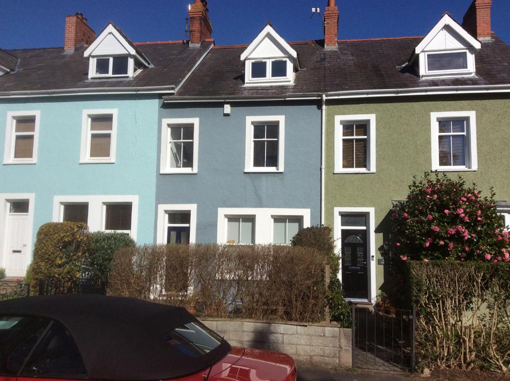 uma casa com um carro vermelho estacionado em frente em Lovely Victorian town house close to the sea. em Bangor