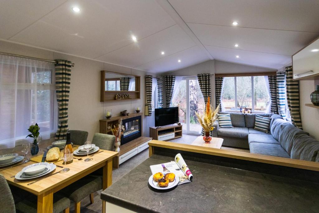 ein Wohnzimmer mit einem Sofa und einem Tisch in der Unterkunft Sea Squirrel - Norfolk Cottage Agency in Holt