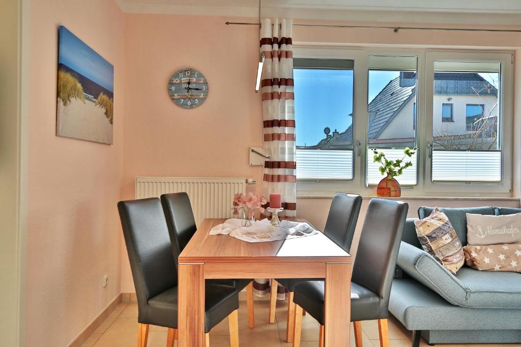 - une salle à manger avec une table, des chaises et un canapé dans l'établissement Residenz Seeschwalbe Residenz Seeschwalbe Appartement 4, à Scharbeutz