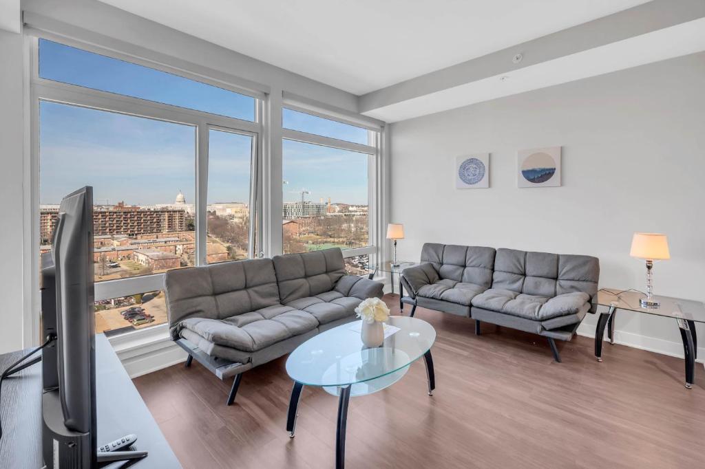 a living room with two couches and a tv at Capitol Hill Fully Furnished Apartments in Washington, D.C.