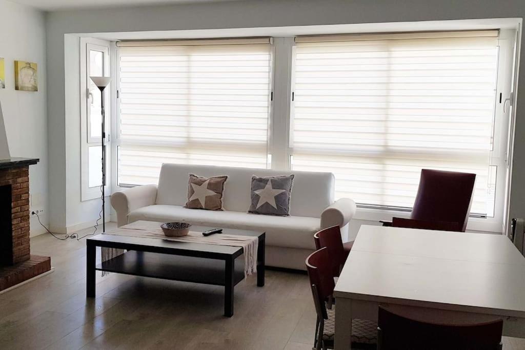 ein Wohnzimmer mit Sofa und Tisch in der Unterkunft Casa cómoda y equipada para 6 en centro pueblo in Torroella de Montgrí