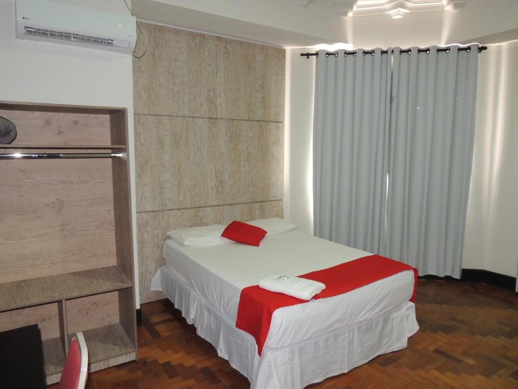 a bedroom with a bed with a red blanket at Hotel Gontijo Belo Horizonte - Próximo a Rodoviária e Praça Sete in Belo Horizonte