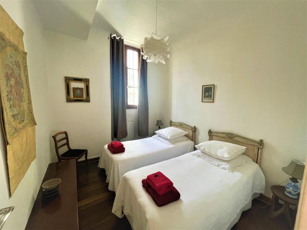 - deux lits dans une chambre avec deux sacs rouges dans l'établissement Très bel appartement dijonnais place Wilson GUTEMBERT, à Dijon