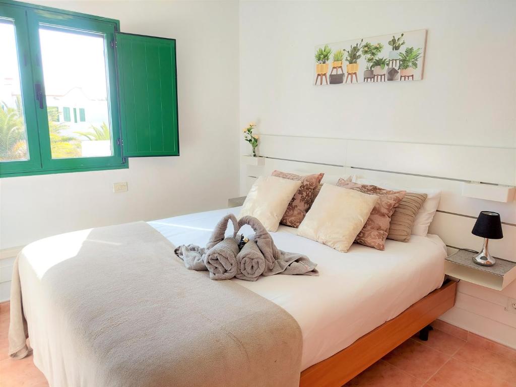 コティージョにあるOcean Balcony by Sea You There Fuerteventuraのベッドルーム1室(ベッド1台、動物2匹の詰め物付)