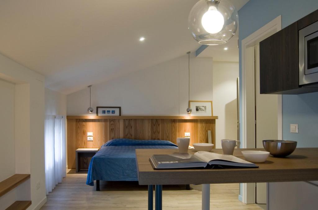 una camera con un letto e un tavolo con un libro di Hotel Oliva ad Aviano
