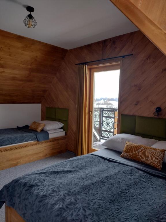 sypialnia z 2 łóżkami i oknem w obiekcie Na Południe w mieście Białka Tatrzanska