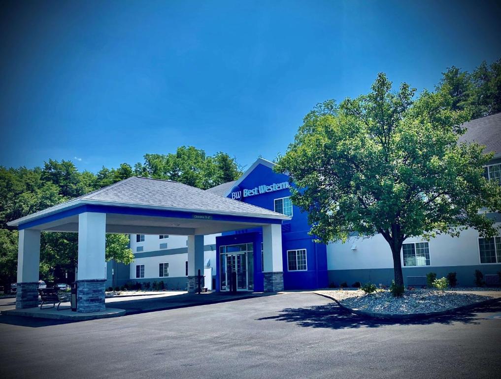 ein blau-weißes Gebäude mit einem Baum davor in der Unterkunft Best Western Brockport Inn & Suites in Brockport