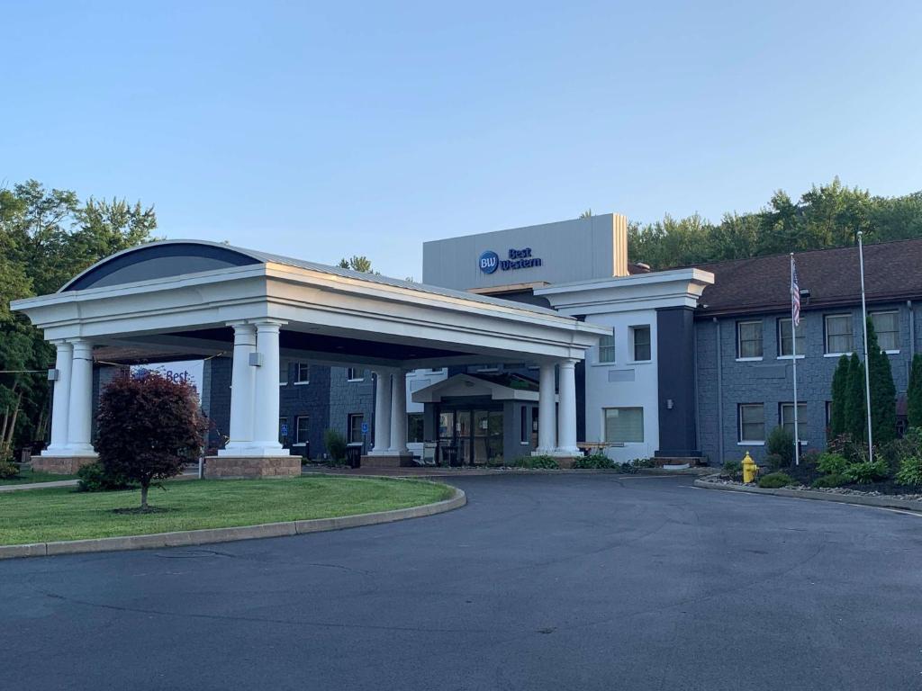 um edifício de hotel com um parque de estacionamento em frente em Best Western Owego Inn em Owego