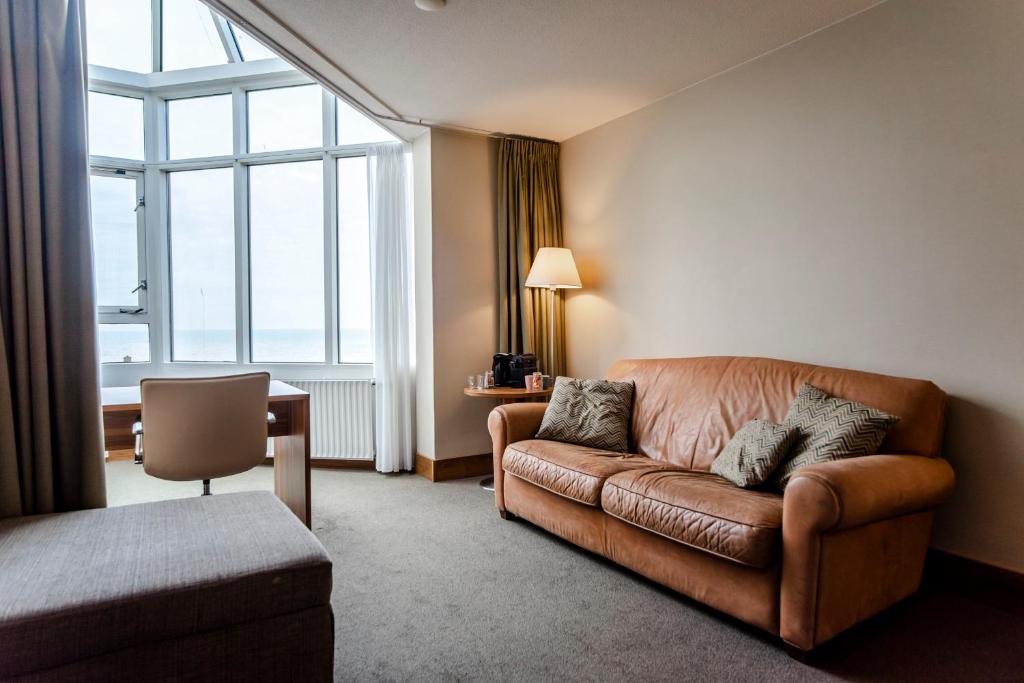 a living room with a couch and a large window at Private Suite with stunning sea view in Zandvoort