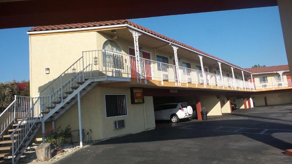 a building with a car parked in a parking lot at Budget Inn Motel in San Gabriel