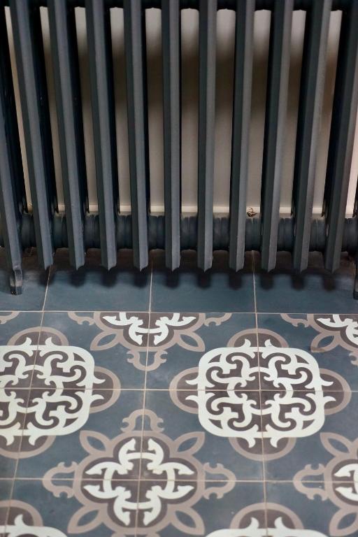 a room with a radiator and a tile floor at Kermaria Studio Suite in Pont-Aven