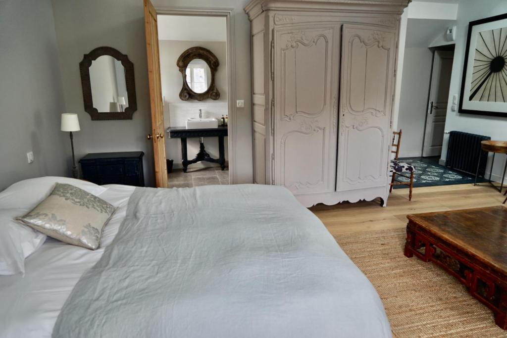 a bedroom with a large white bed and a table at Kermaria Studio Suite in Pont-Aven