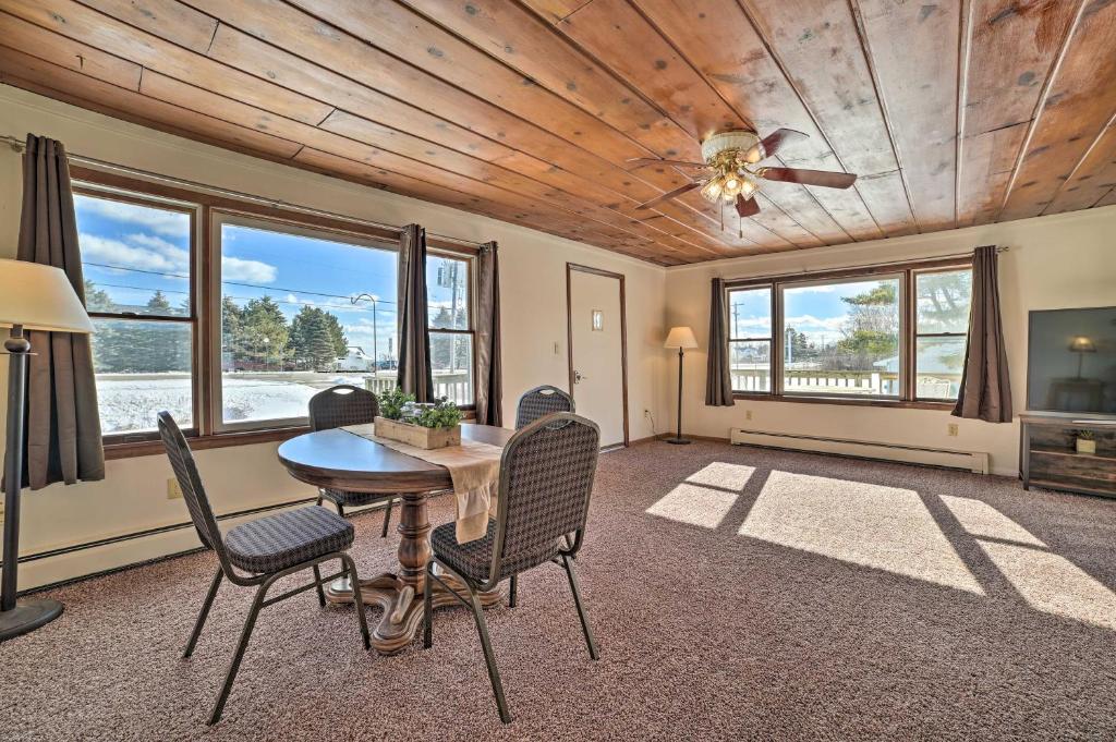 a dining room with a table and chairs and windows at Cozy Tawas City Home with Views of Lake Huron! in Tawas City