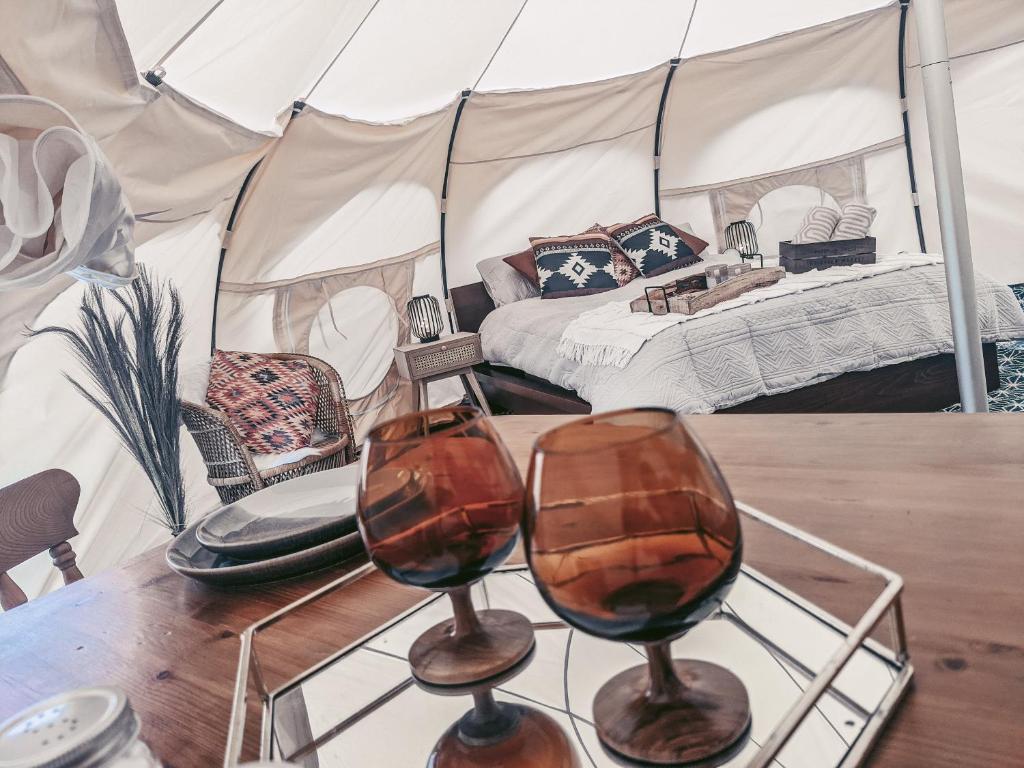 ein Zelt mit zwei Weingläsern auf dem Tisch in der Unterkunft Immaculate Lotus Belle Tent Retreat North Devon in Bideford