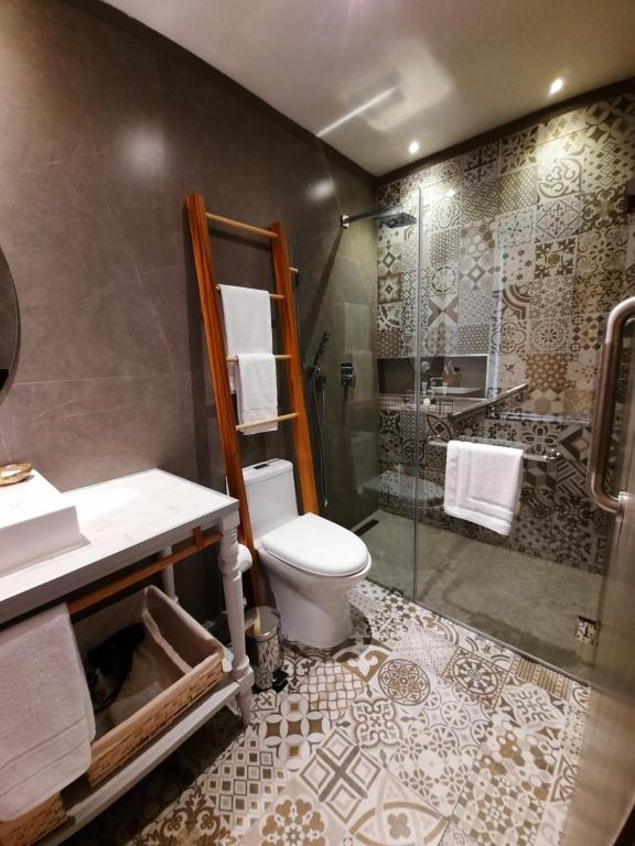a bathroom with a shower and a toilet and a sink at Hostal Suite Le Fabrique in Cuenca