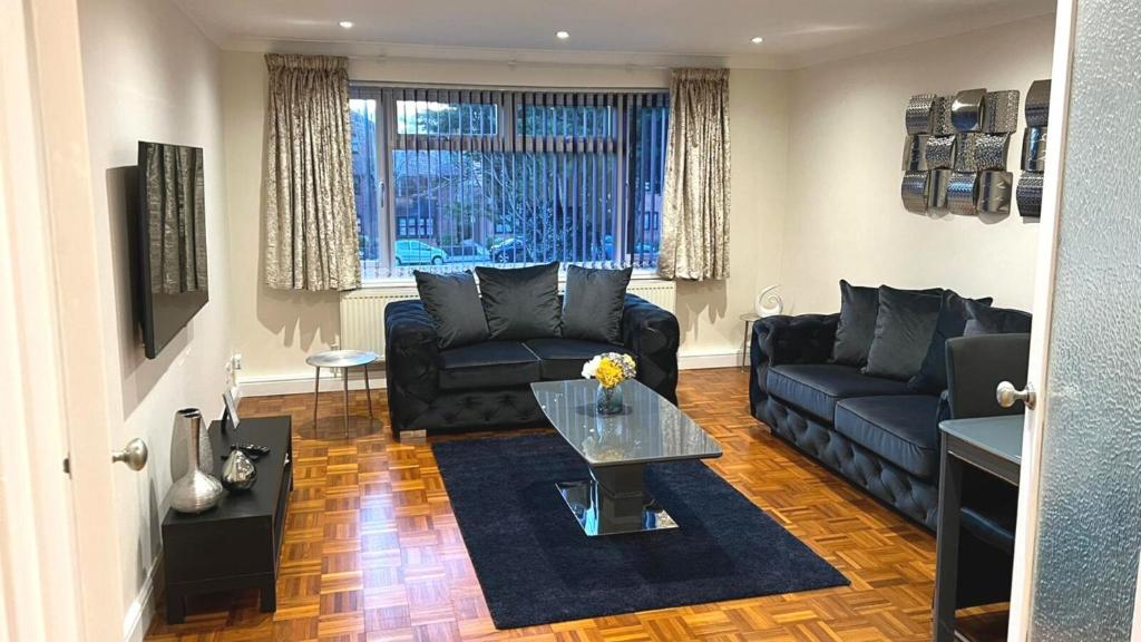 a living room with a couch and a table at FW Haute Apartments at Stanmore, 3 Bedrooms and 1 Bathroom with additional WC, Single or Double Beds, Pet-Friendly Flat with FREE WIFI and PARKING in Stanmore