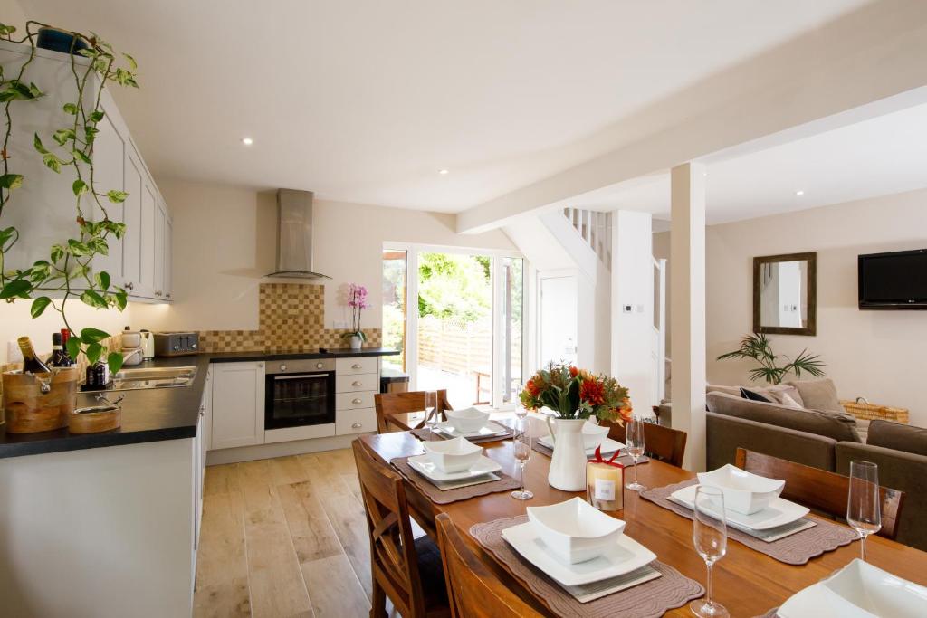 Il comprend une cuisine et un salon avec une table à manger. dans l'établissement ' ORCHARD CROFT LODGE ', BRAND NEW HOME , ' Massive 1,367 Sq' Ft', Sleep's 7 on request , Split & Link 'Super King' Size Beds, Free Wi-Fi, Sky TV & Sky Sports, 8 Minutes from West Wittering Beach, Quiet Location, DOG FRIENDLY, Private Parking for 8 Cars, à Chichester