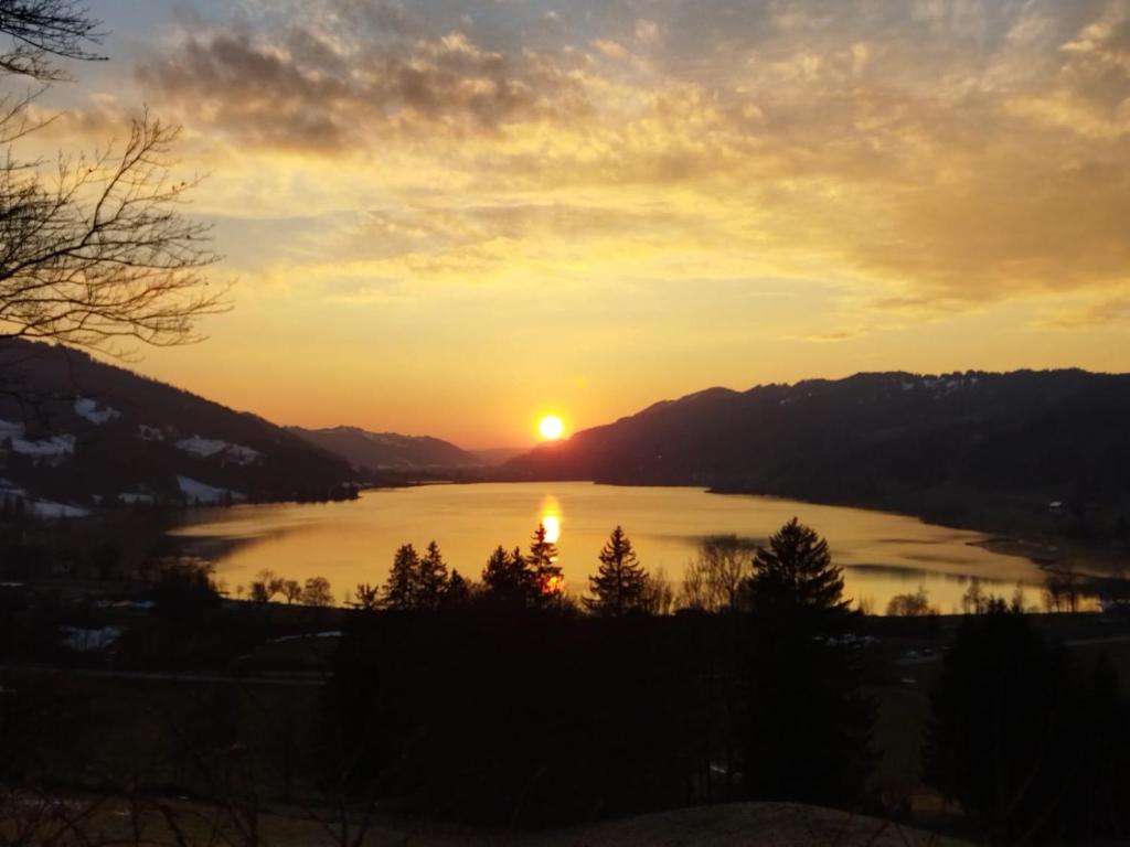 - un coucher de soleil sur un lac dans l'établissement Fewo FRIADO im Ferienpark OA - ohne Zusatzkosten nach Anreise - mit Hallenbad, W-Lan, PKW-Garage, Kurtaxe mit Allgäu-Walser-Pass, Bett- und Handtuch-Wäsche sowie End-Reinigung, à Missen-Wilhams