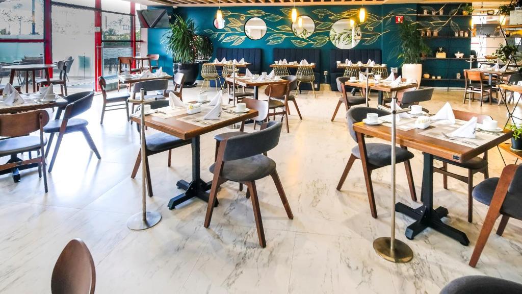 a dining room with wooden tables and chairs at Metria Hotel in León