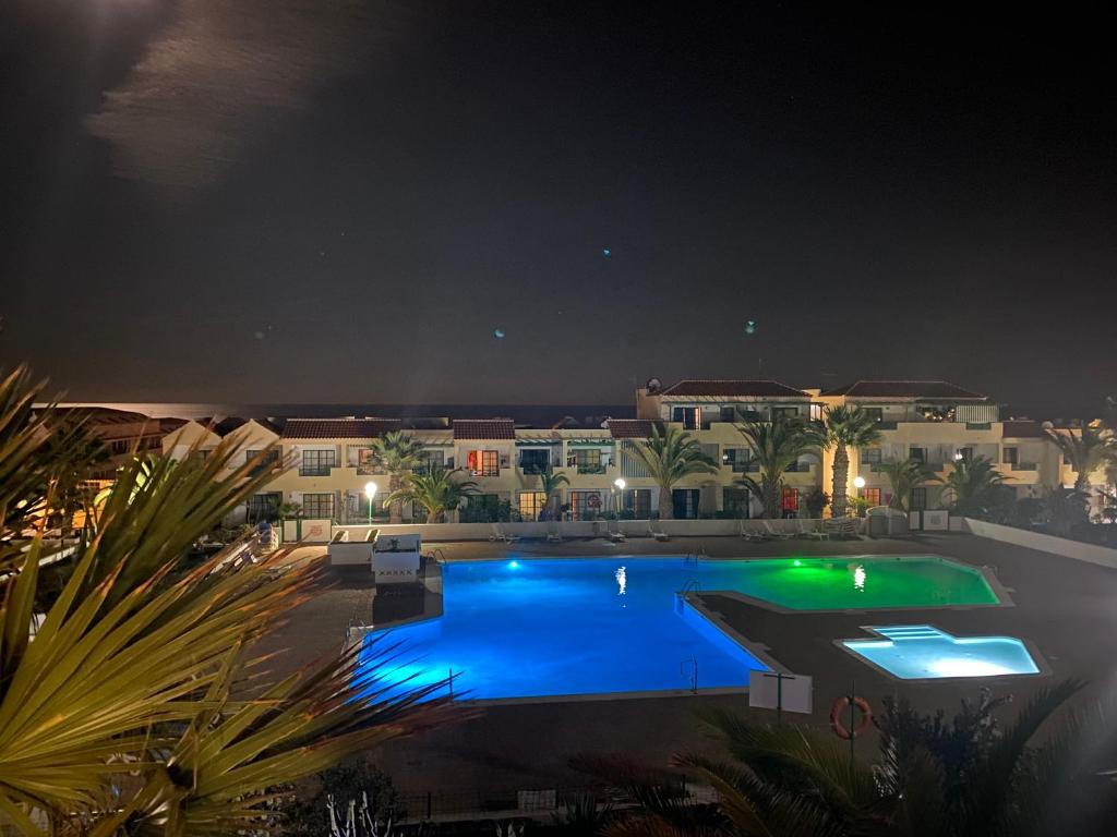 a large swimming pool at night with a resort at Las Torres del Castillo, 208Marina in Costa de Antigua