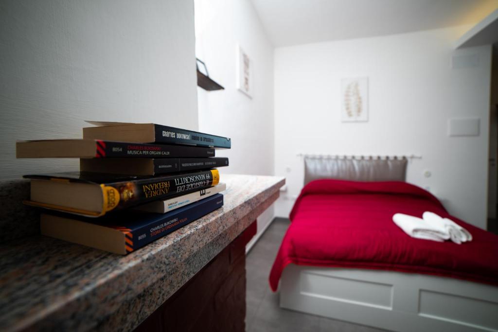 uma pilha de livros sentados num balcão ao lado de uma cama em B&B Le Sorelle em Giffoni Valle Piana