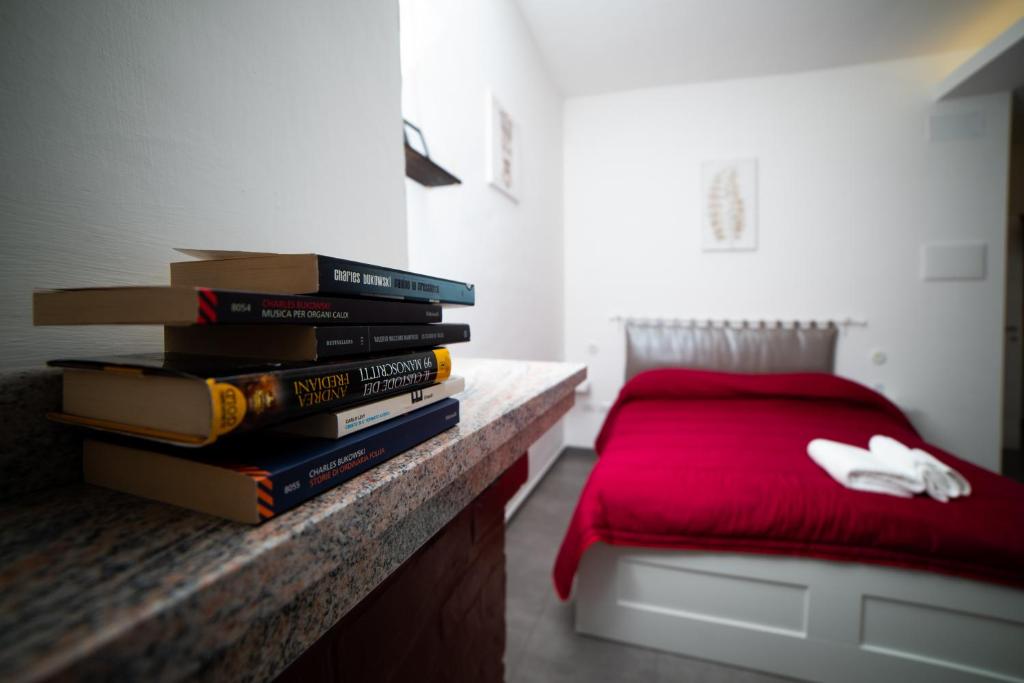 una pila de libros sentados en un mostrador junto a una cama en B&B Le Sorelle, en Giffoni Valle Piana