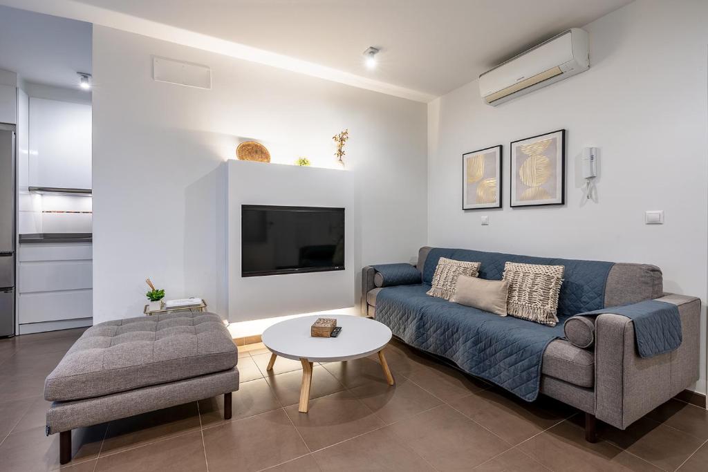 een woonkamer met een blauwe bank en een tafel bij tuGuest S.Pedro Apartments in Granada