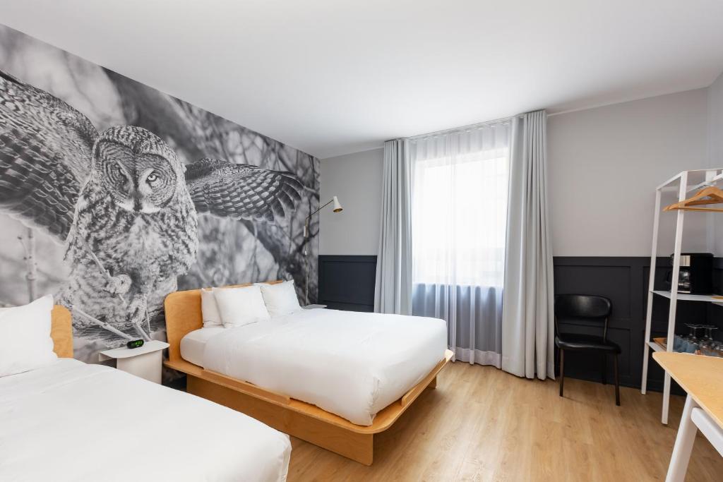 a bedroom with two beds and a mural at Hôtel du Jardin - Par Les Lofts Vieux-Québec in Quebec City