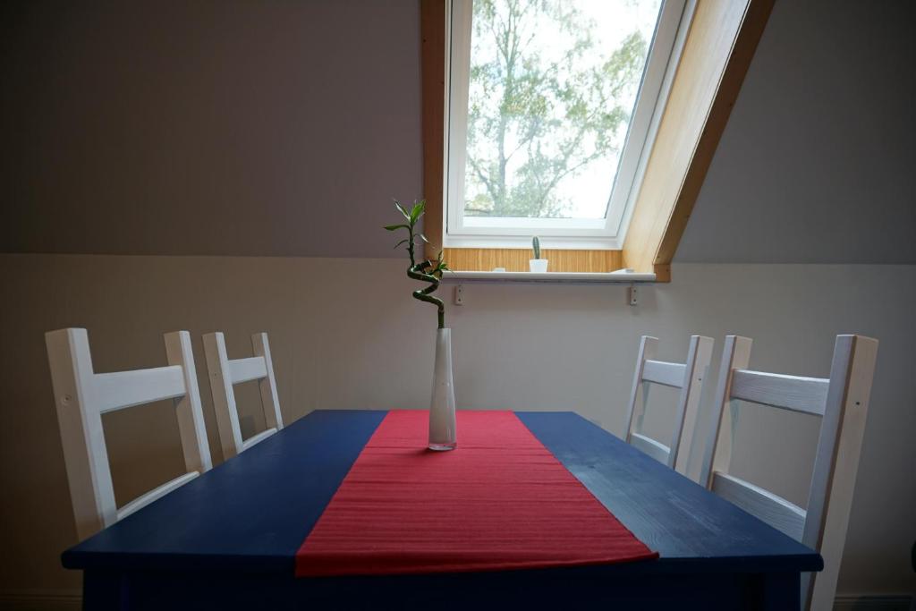 einen Tisch mit einer Vase darüber mit einem Fenster in der Unterkunft Gemütliche Apartments in der Heide in Soltau