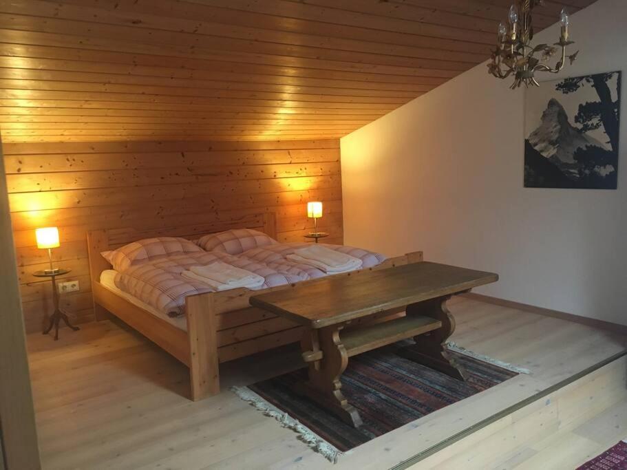 um quarto com uma cama e uma mesa de madeira em Gundhabing flat em Kitzbühel