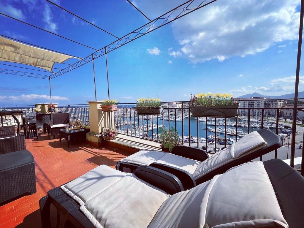 a balcony with couches and a view of the ocean at Kasa Kala Rooms & Apartments in Palermo