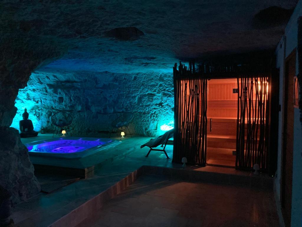 um quarto escuro com uma banheira numa caverna em Le Chateau de la Barre em Mosnes