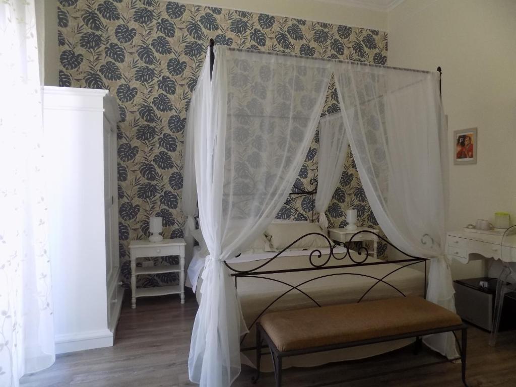 una camera con un letto bianco a baldacchino di Il Sonaglio a Palermo