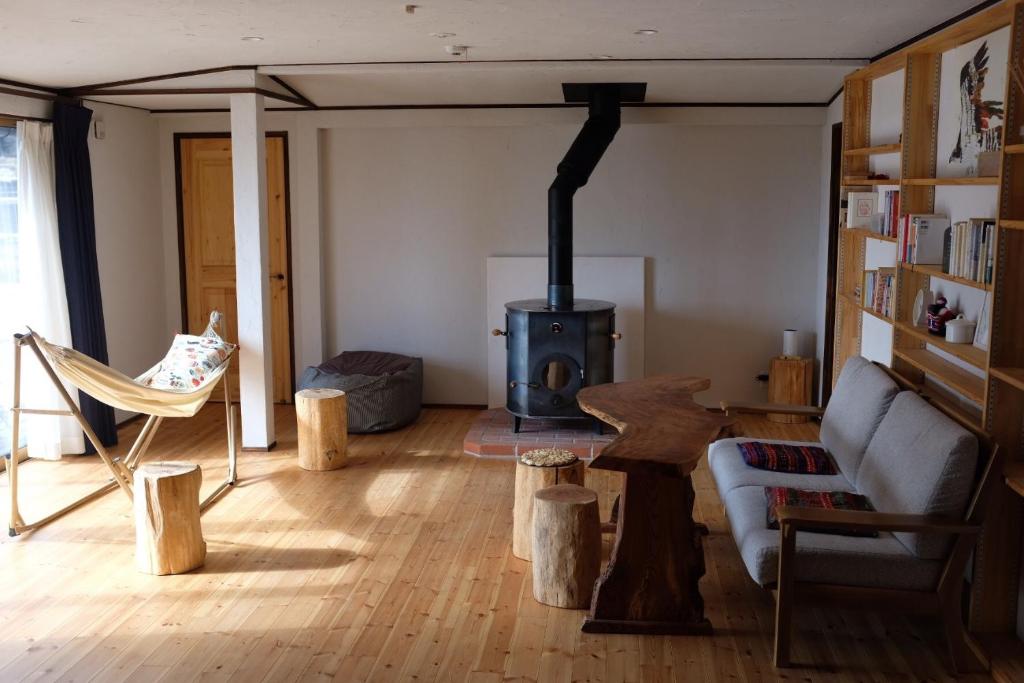 uma sala de estar com um sofá e um fogão a lenha em Azumino Fukuro Guesthouse - Vacation STAY 21913v em Azumino