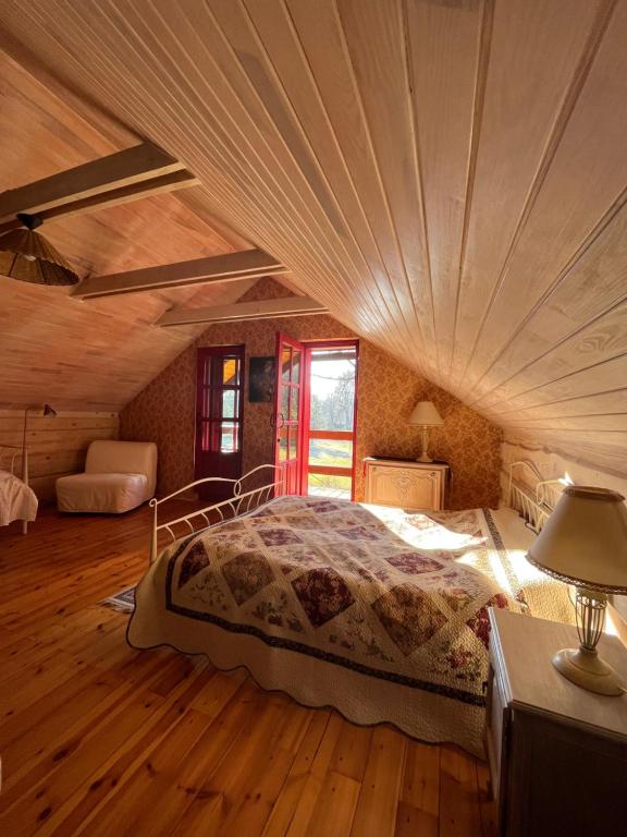 a bedroom with a large bed in a wooden ceiling at Begedziu misko sodyba in Grynaičiai