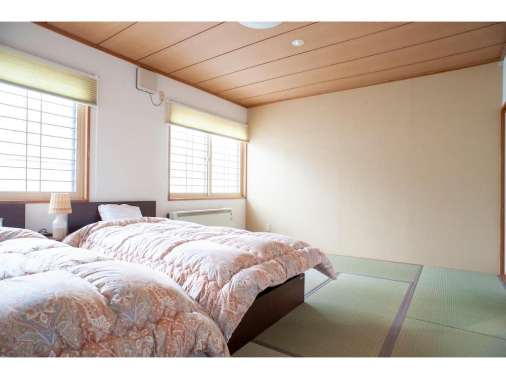 two beds in a room with two windows at Guest House Tou - Vacation STAY 26352v in Kushiro
