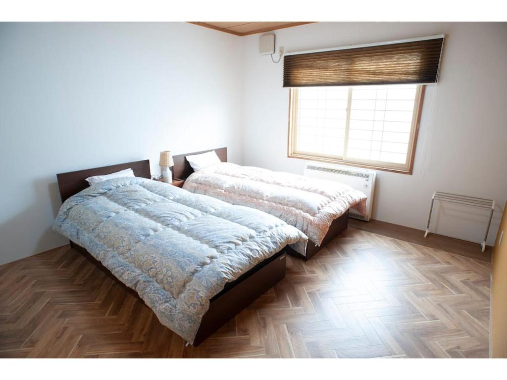 a bedroom with two beds and a window at Guest House Tou - Vacation STAY 26359v in Kushiro