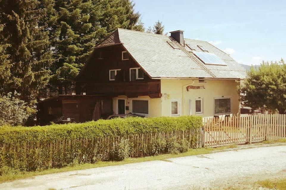 een bruin en wit huis met een hek bij Gästehaus Deisl in Mariapfarr