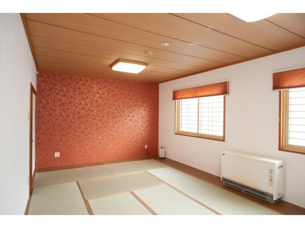 Habitación vacía con paredes rojas y techo. en Guest House Tou - Vacation STAY 26348v, en Kushiro