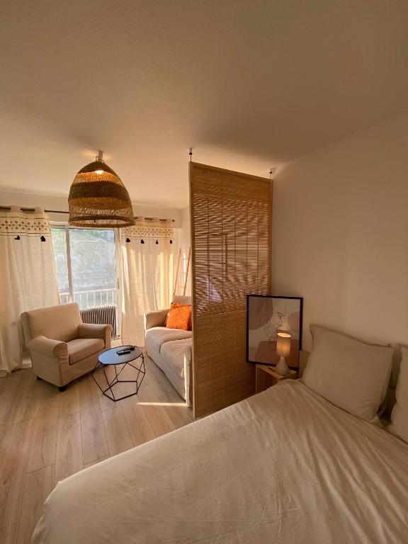 une chambre avec un lit et un salon avec un canapé dans l'établissement Studio bohème - Centre - Proche gare, à Mulhouse