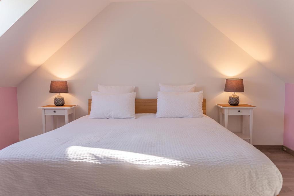 a bedroom with a large white bed with two night stands at Le Cissereau - Chambres et table d'hôtes in Onzain