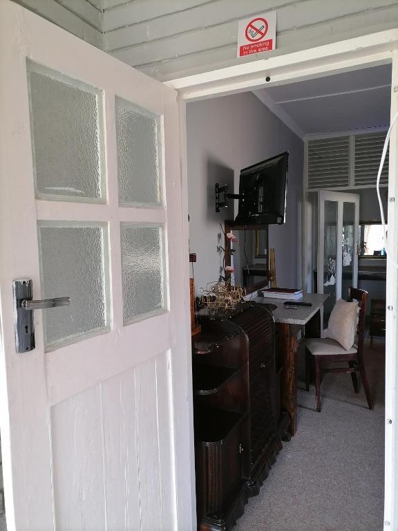 a door to a room with a desk and a television at Adirondack Inn in Estcourt