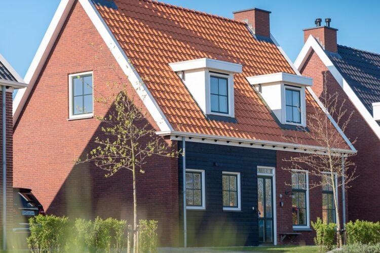 Colijnsplaatにあるluxury 8 person Wellness villa with saunaの赤い屋根の大きな赤レンガ造りの家