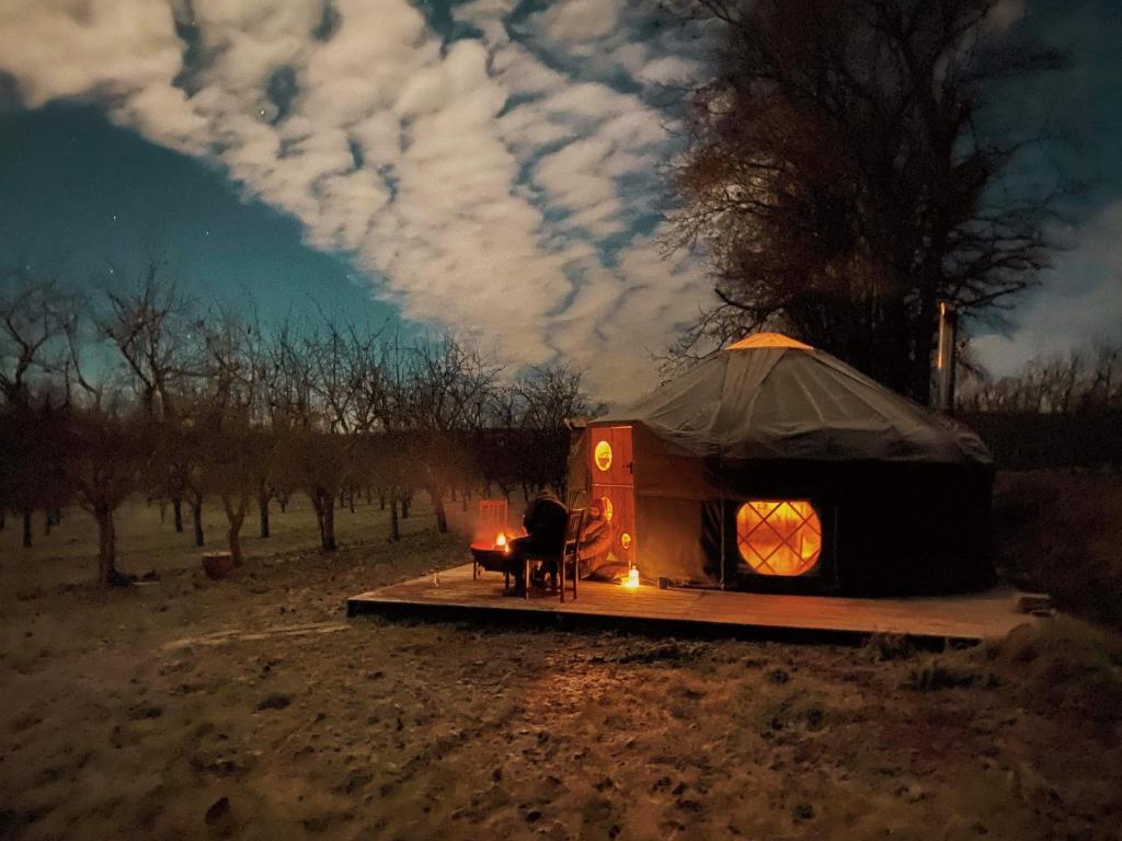 a person sitting in front of a yurt at Dragon Orchard Retreat in Ledbury