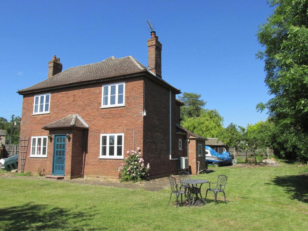 a brick house with a table and chairs in the yard at Large 4 Bedroom House in Norfolk Perfect for Families and Groups of Friends in Stoke Ferry