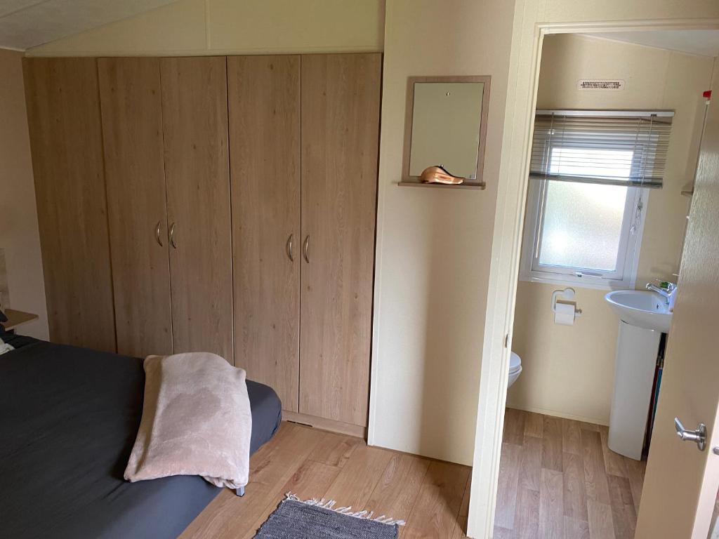 Dormitorio pequeño con cama y lavamanos en DaisyChain 2 Getaways - The perfect place to Stay - Play - Getaway en East Mersea