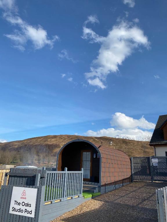 een gebouw met een bord ervoor bij Highland Stays - The Oaks Studio Pod in Fort William