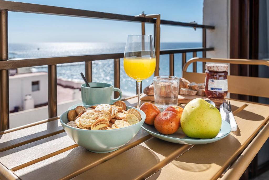 uma mesa com uma tigela de comida e um copo de sumo de laranja em lux&Cool Paseo Marítimo em Almeria